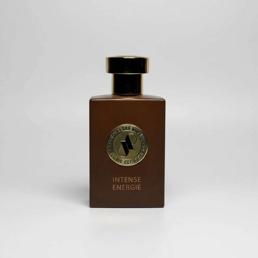 Brown perfume bottle with gold cap and label on a light gray background