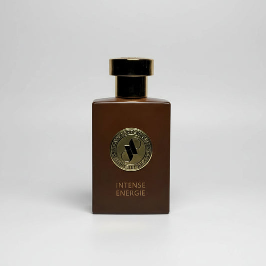 Brown perfume bottle with gold cap and label on a light gray background